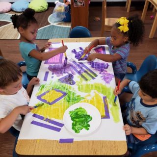 Toddlers painting at childcare center.