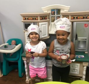 Two year old children playing kitchen in daycare.